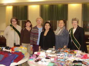 Roxanna Cruz-Johnson and Tran from the Dept. of Children & Families receive donations from project coordinators Deb Goodrich, Patti Gibson, Merryl Havens, and Janet Segur.
